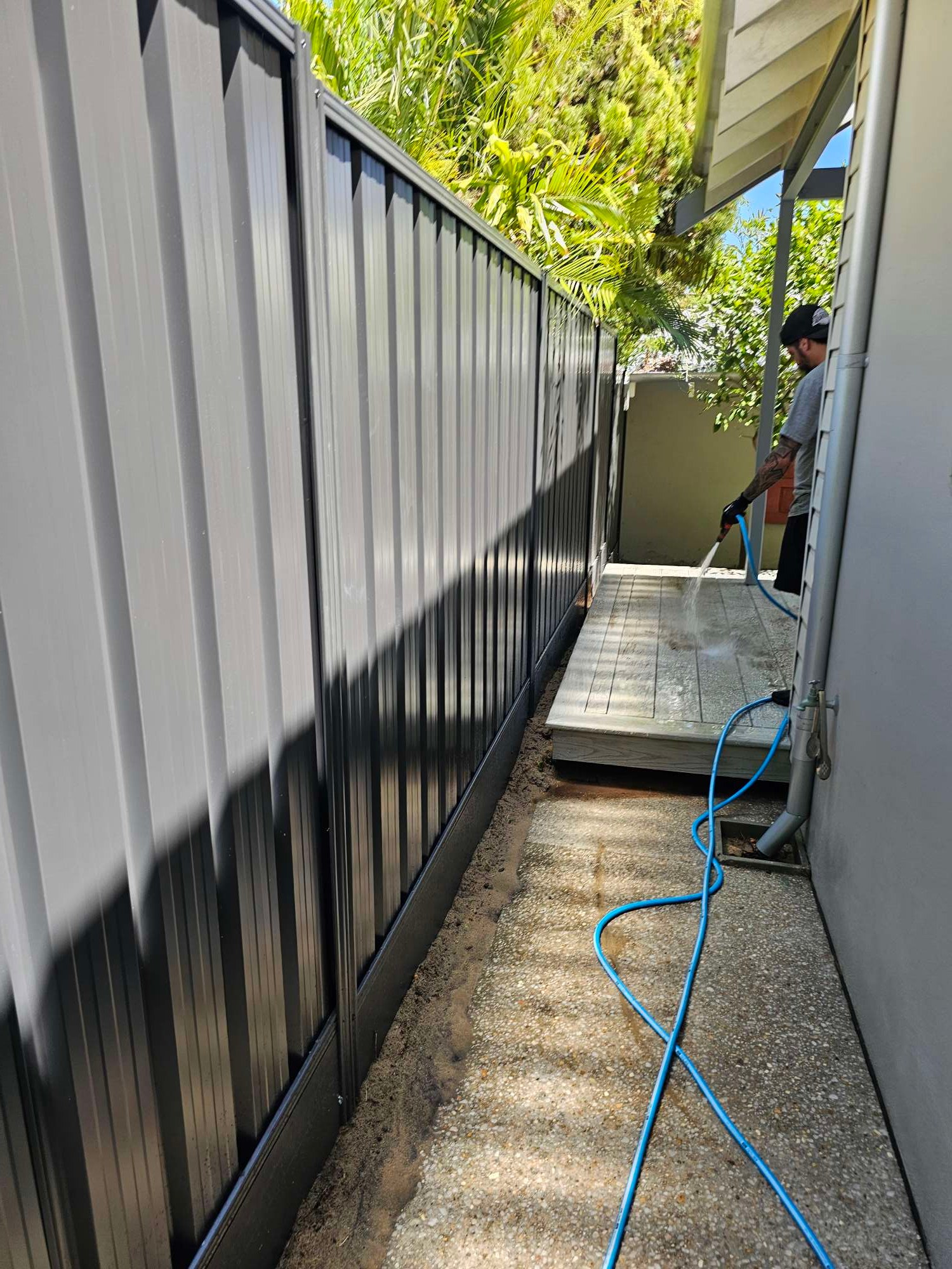 Charcoal Colorbond fence along a narrow side path