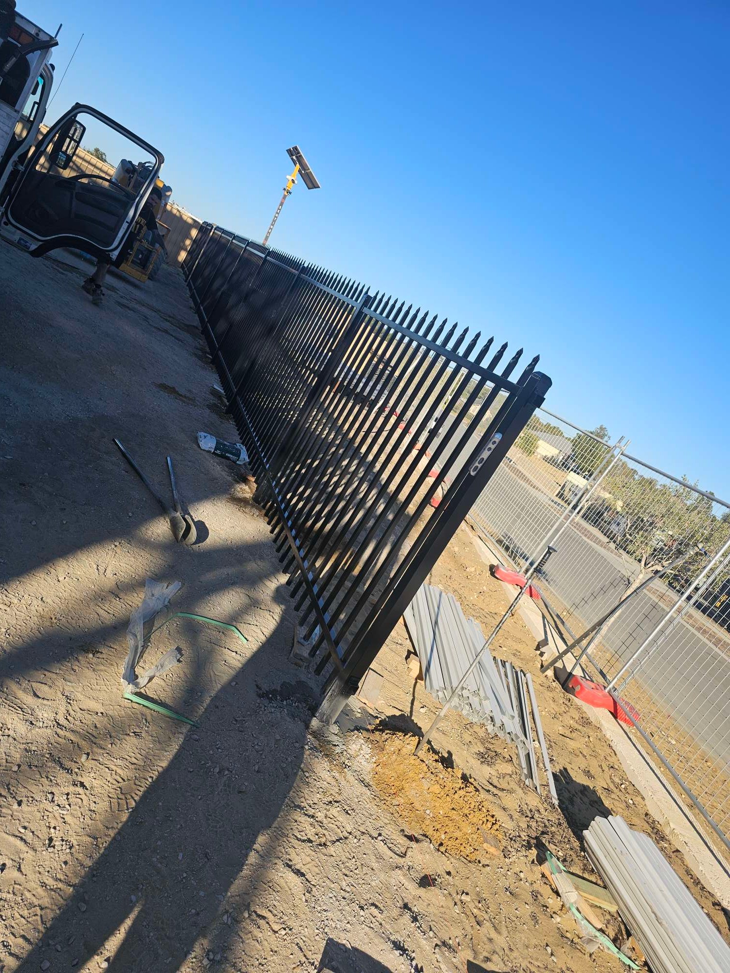 Black powder-coated garrison security fence being installed