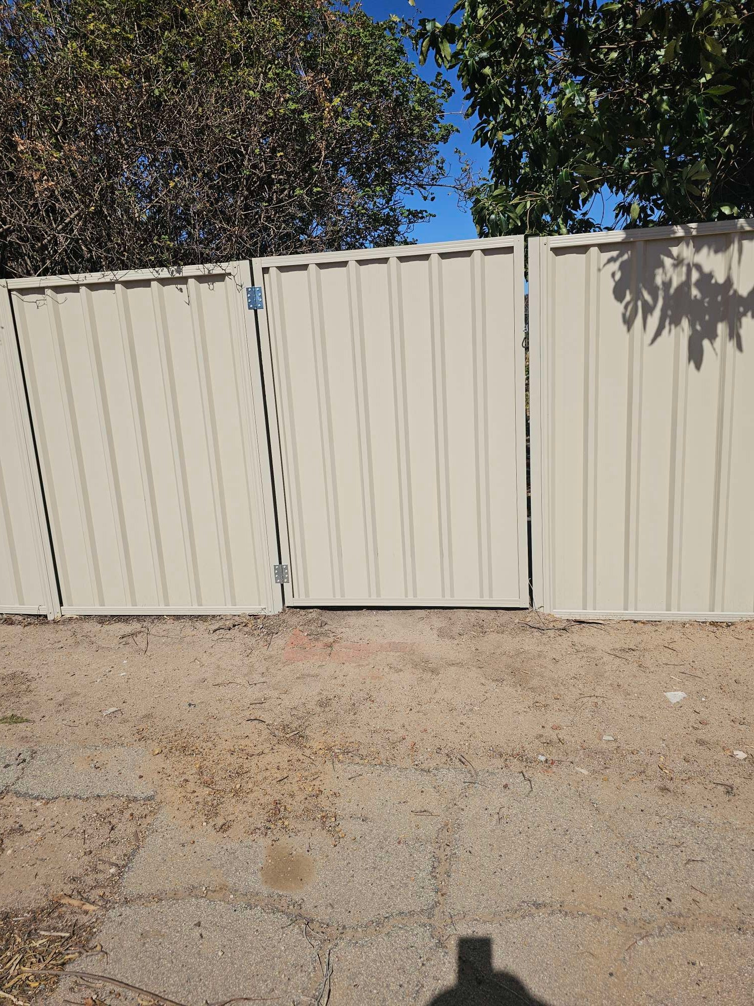 Colorbond fence with matching gate on paving