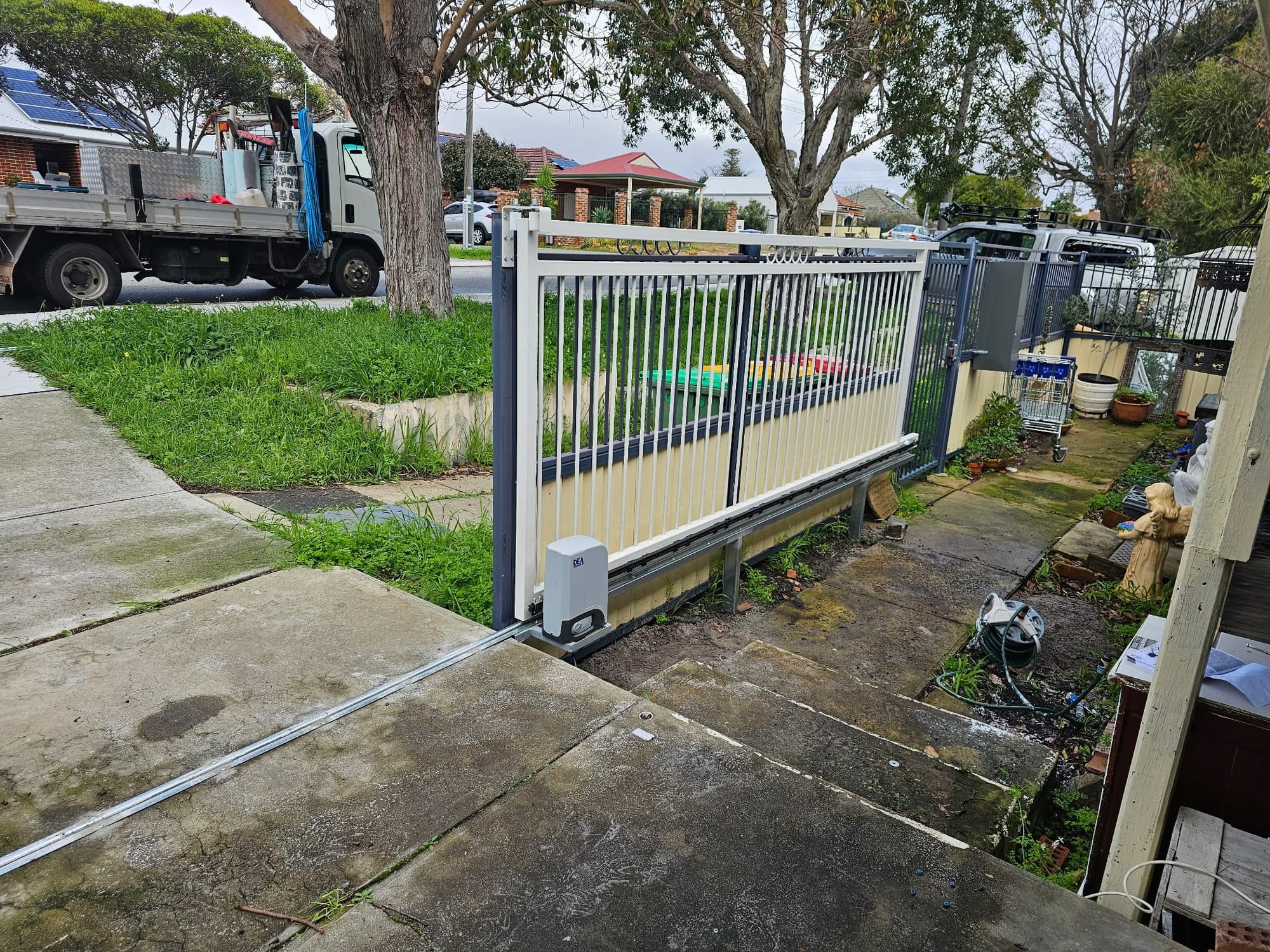 Automated aluminium sliding driveway gate with motor and track at a Perth home