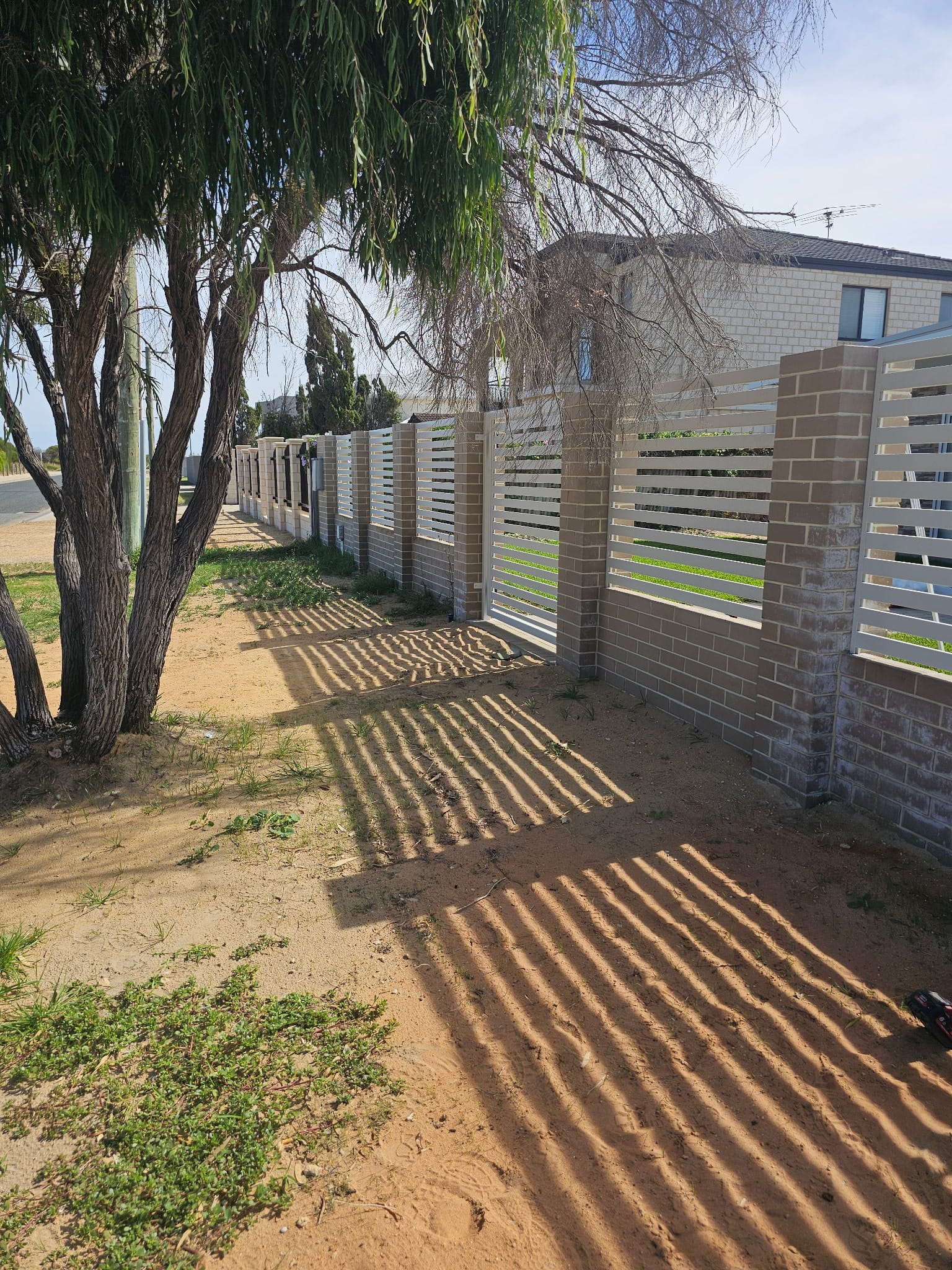 Aluminium slat infill fence between rendered piers