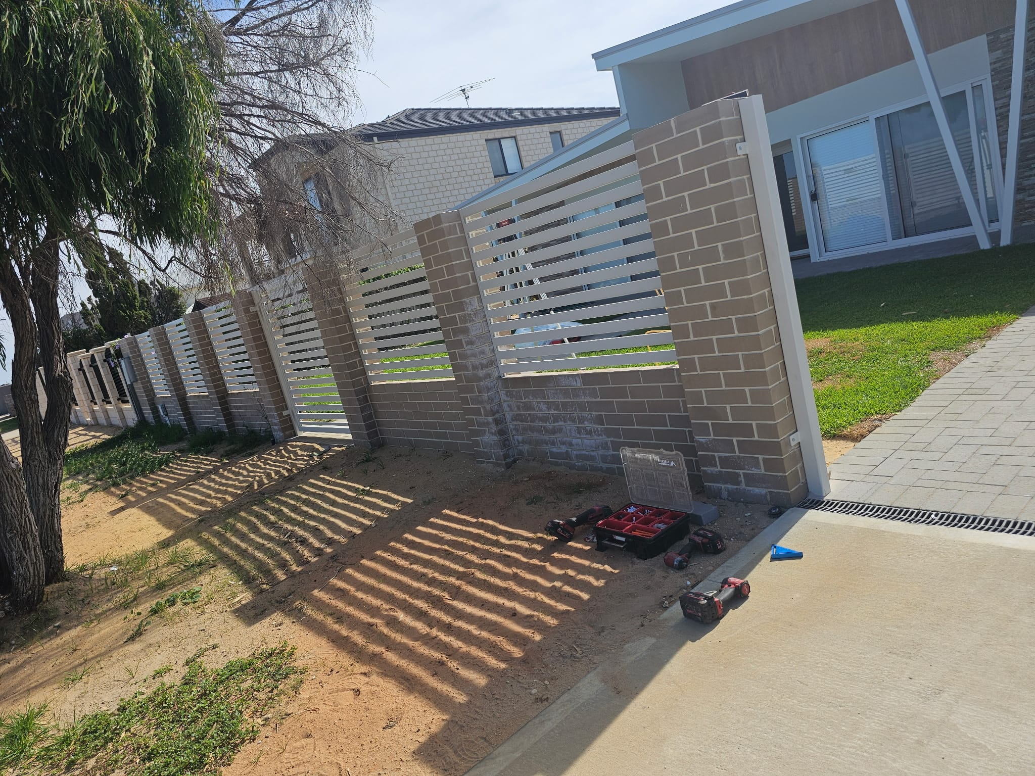 Aluminium slat front fencing with rendered piers on a new home frontage