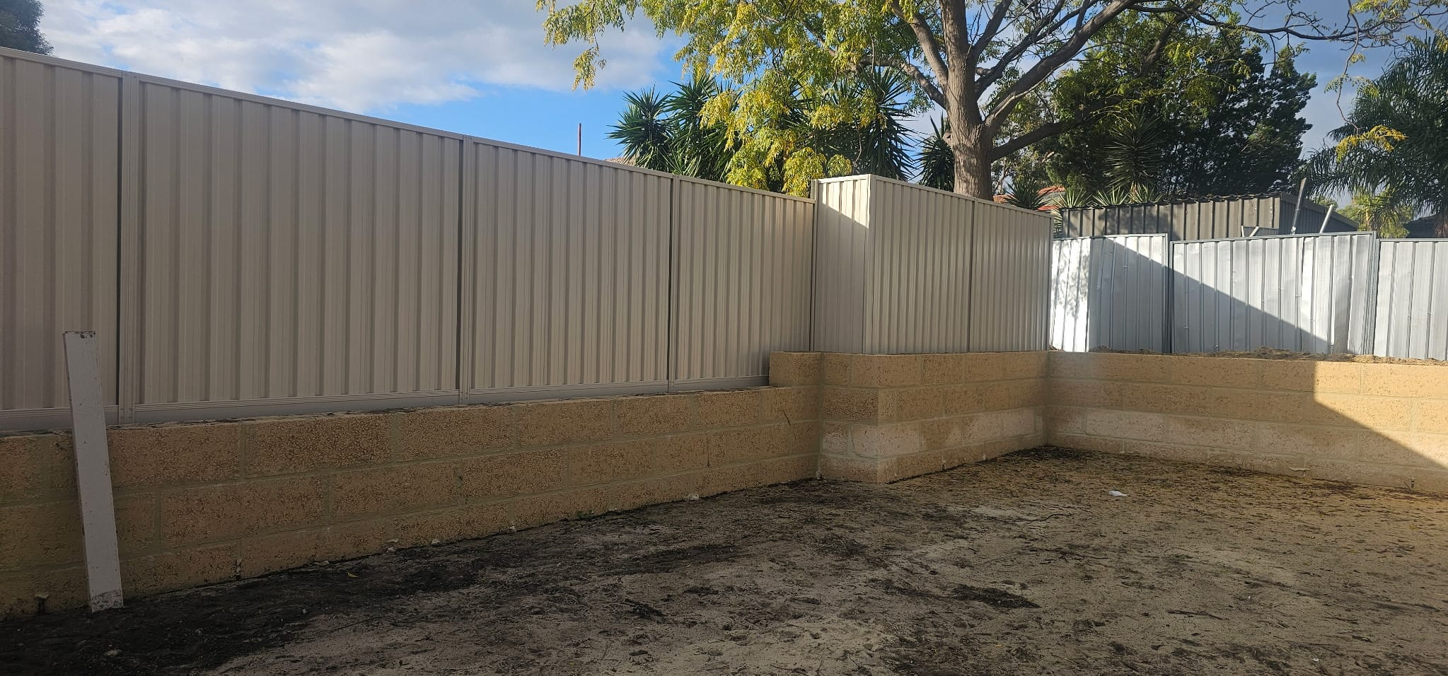 Paperbark Colorbond fence on a limestone block retaining wall