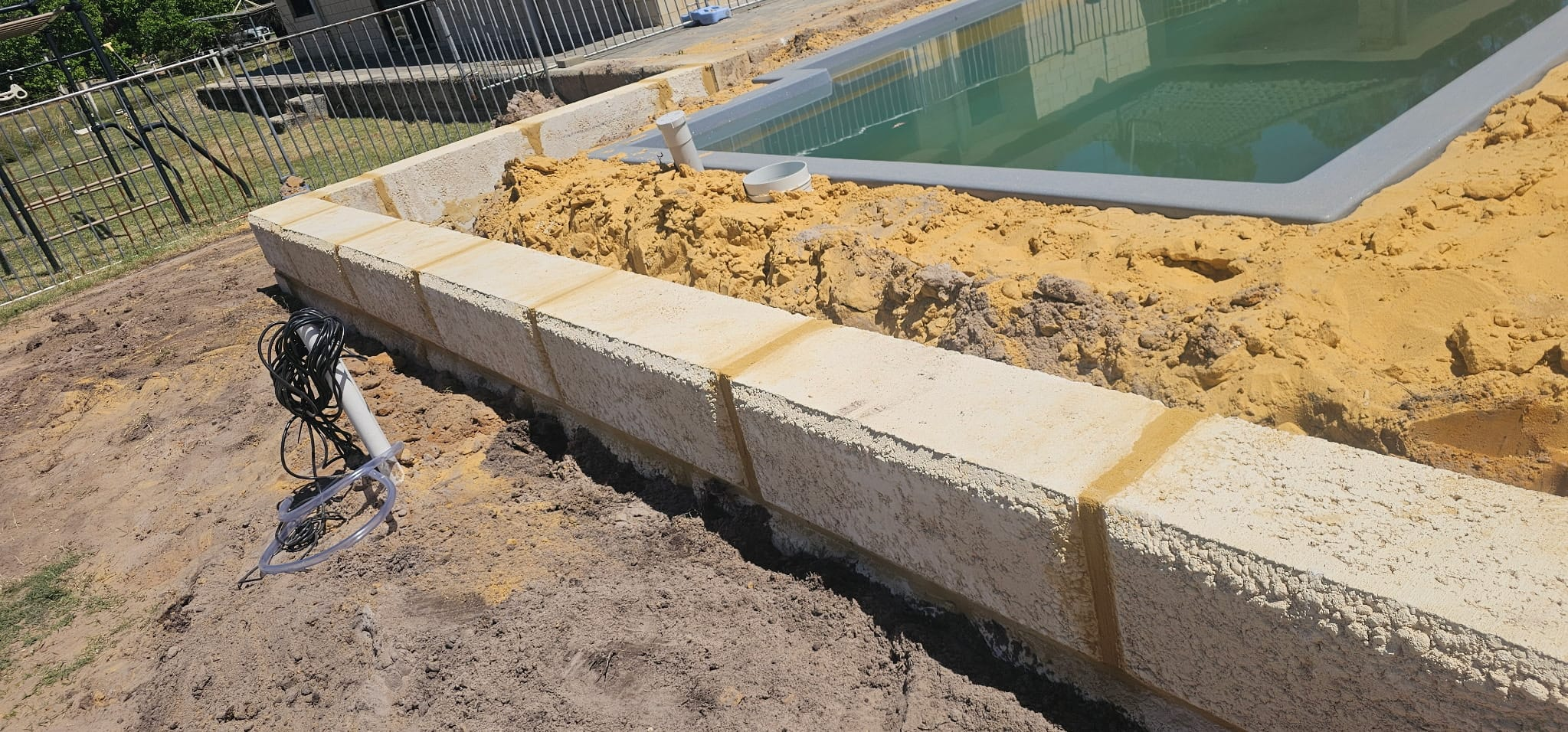 Limestone block retaining wall built around a new pool