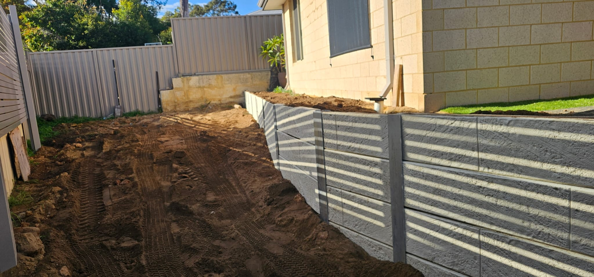 Concrete sleeper retaining wall running down a side boundary