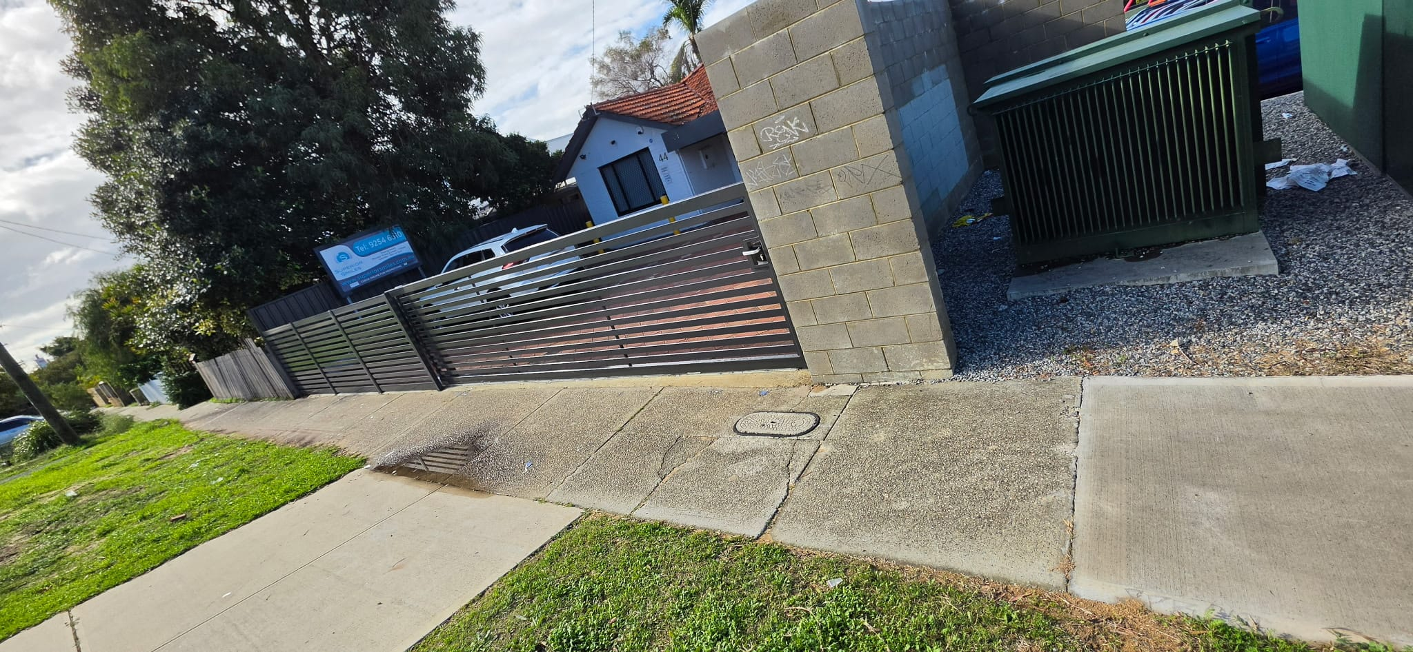 Aluminium slat sliding driveway gate at a commercial entry