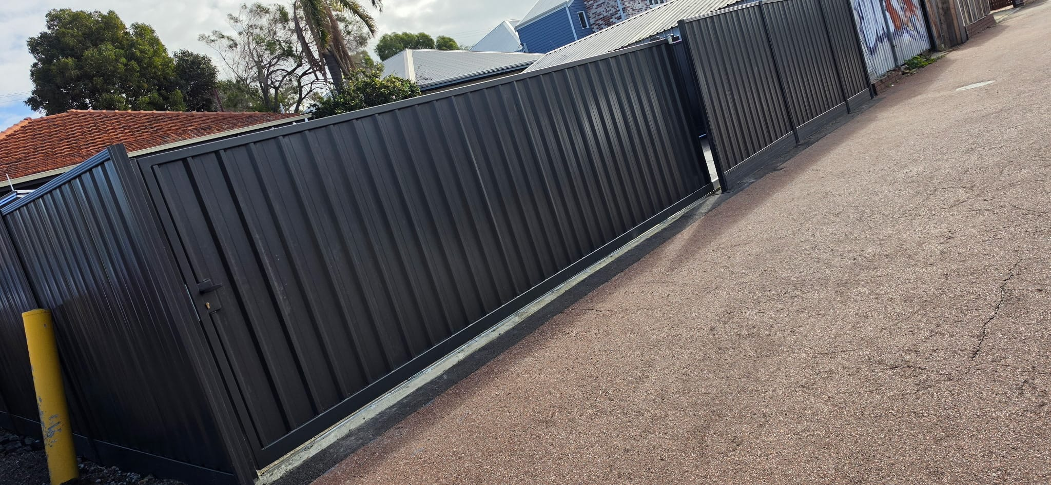 Monument black Colorbond fence with matching gates along a Perth rear laneway