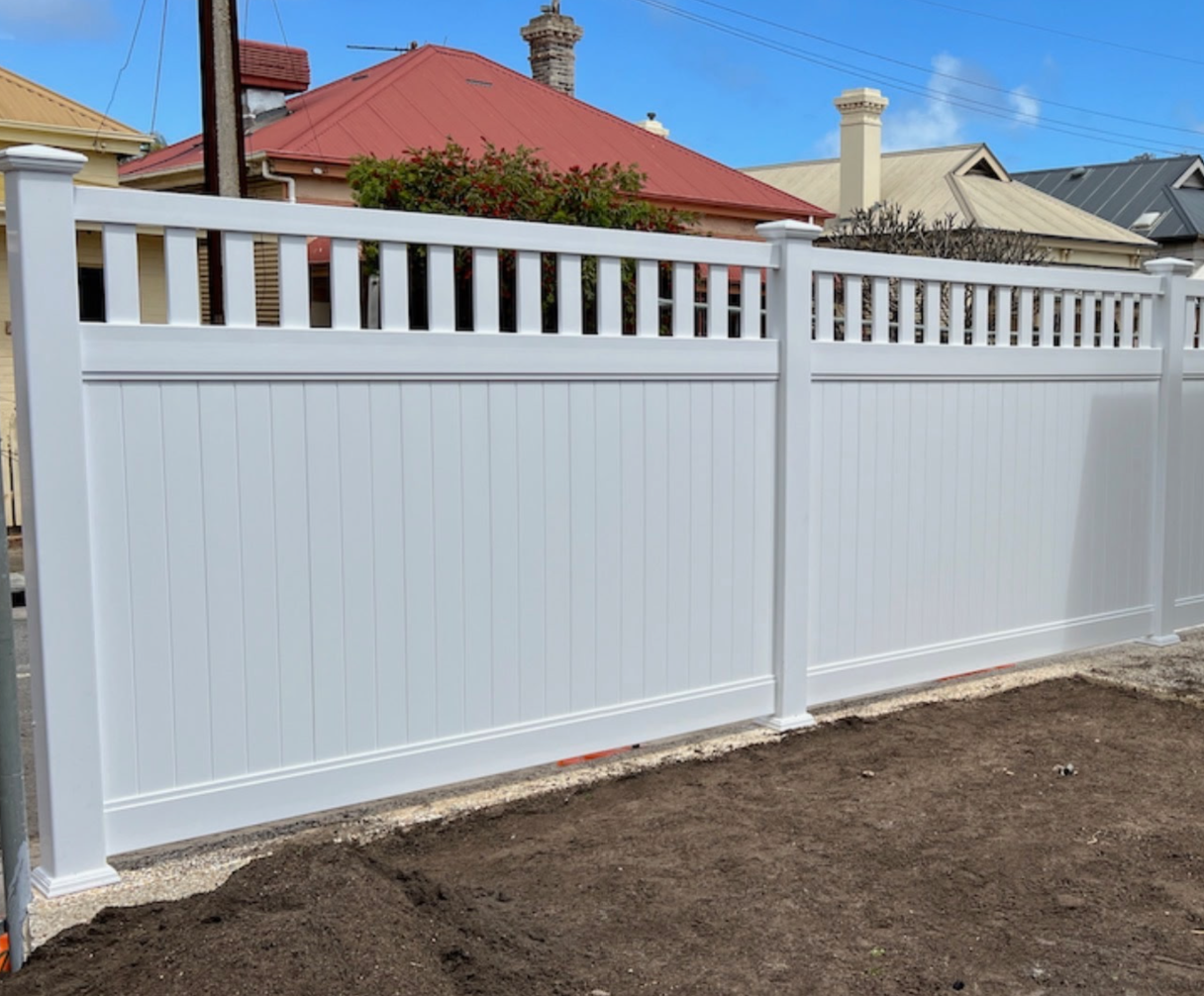 Solid white PVC privacy fence with an open picket top section along a street boundary